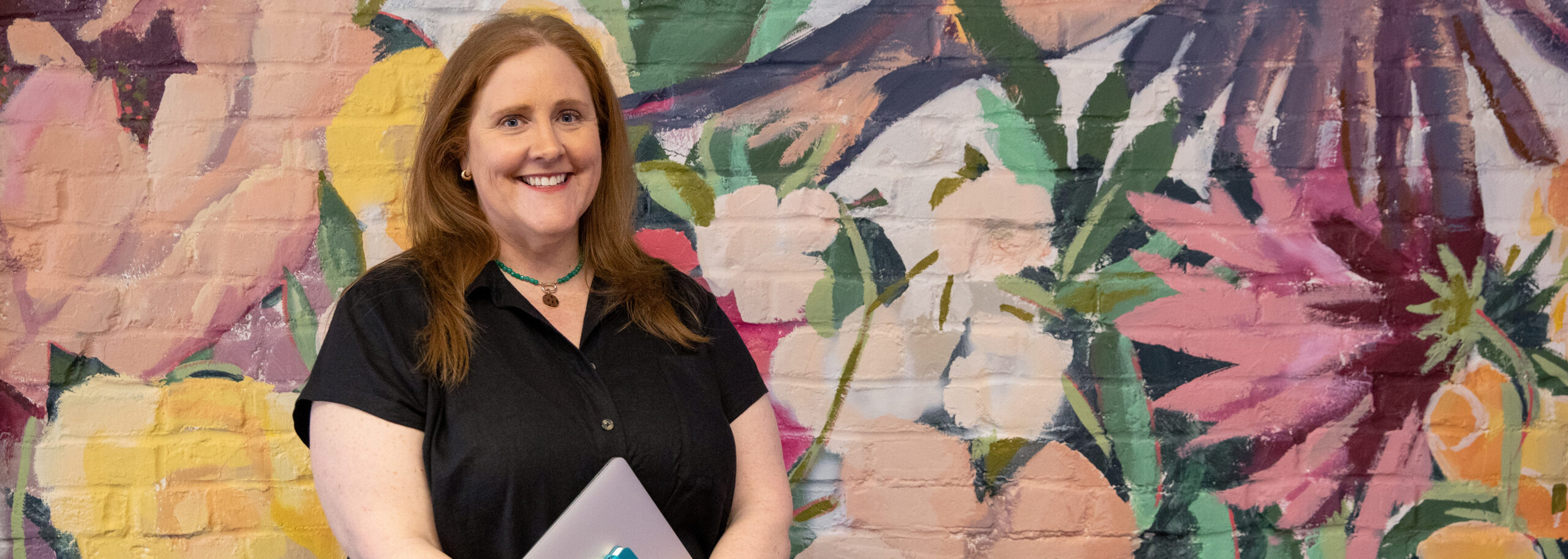 Kristyn Dunlap KayKay Consulting Group in front of a Mural